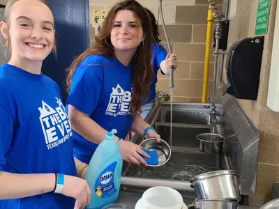 two volunteers washing bowls
